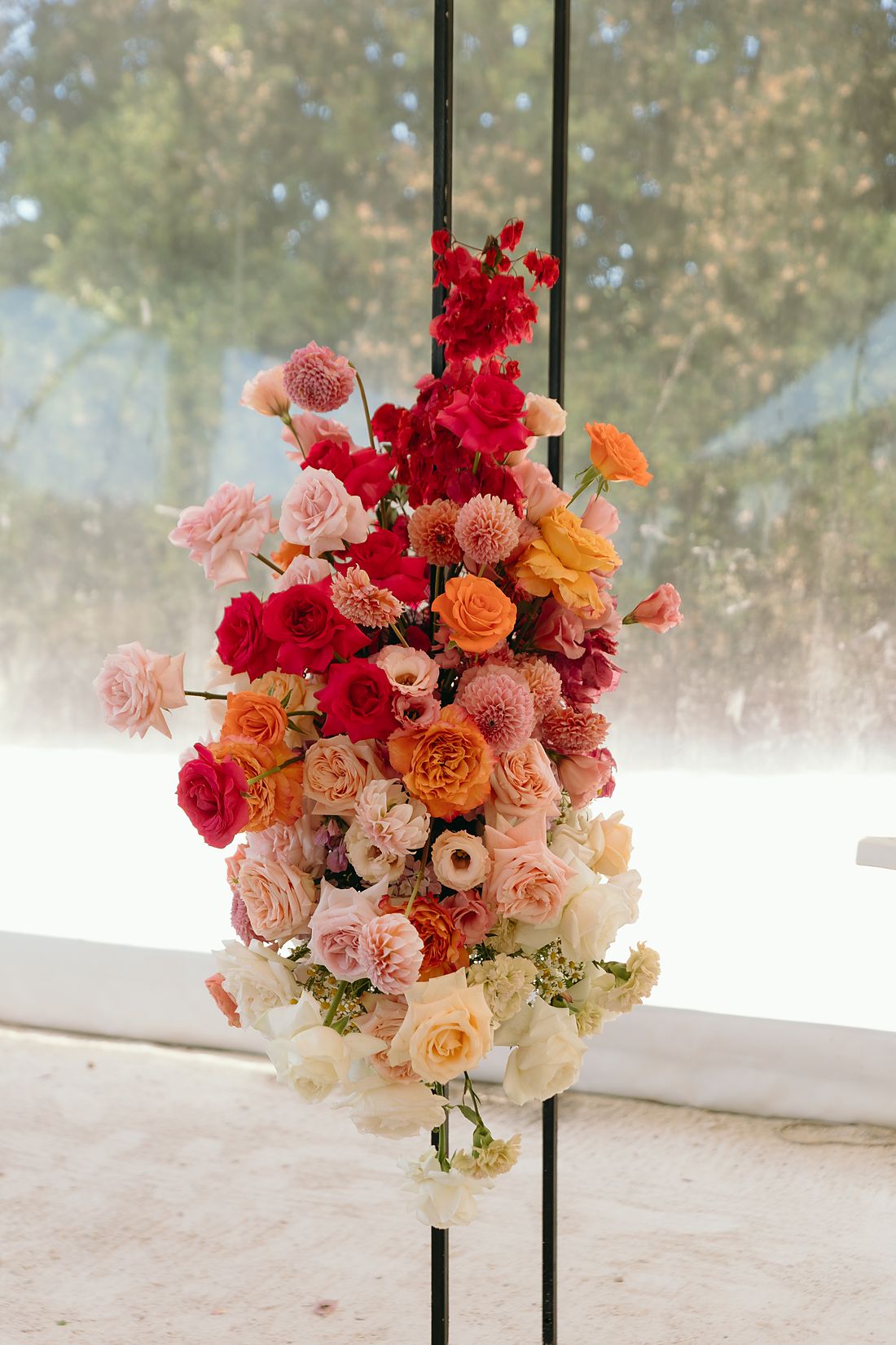 A ceremony arrangement in coral, red and cream