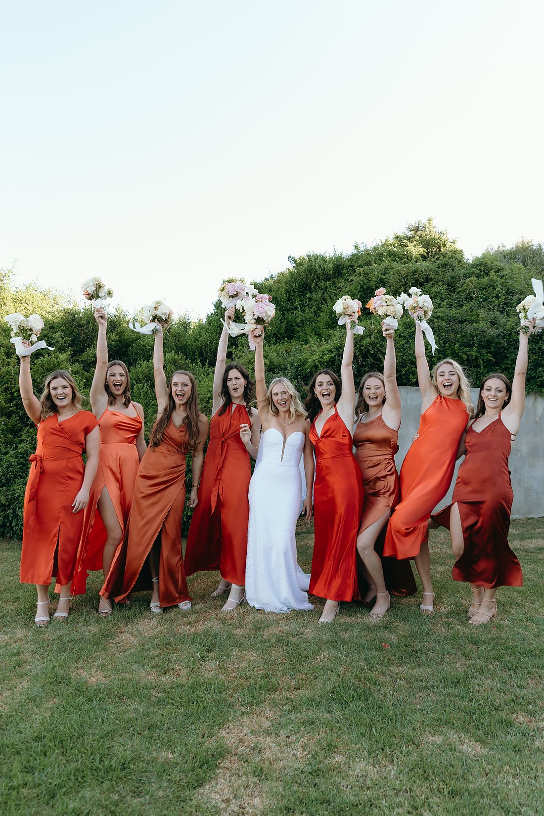 A bride and her bridesmaids on the lawn at The Rose Barn