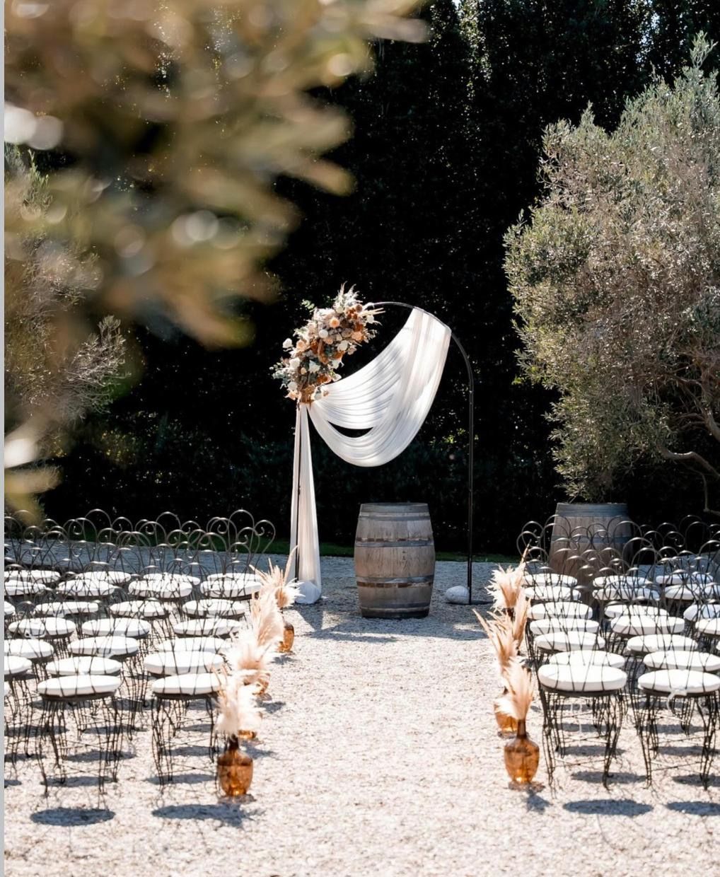 A ceremony aisle set beneath the trees in the garden grove