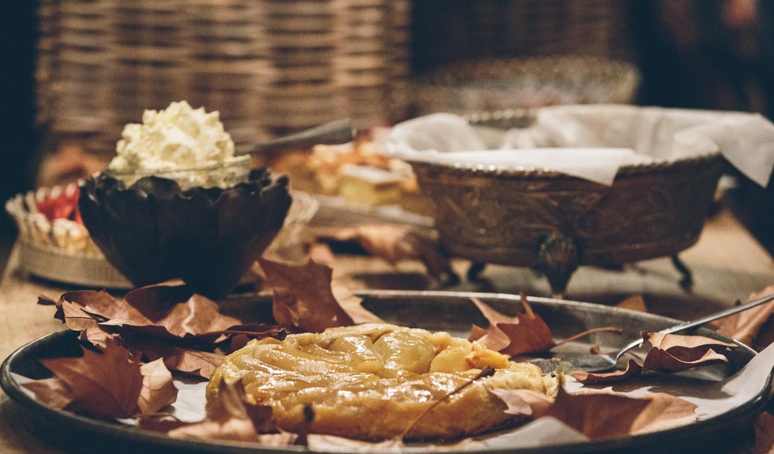 A warm dessert table with tarte tatin and cream in the barn