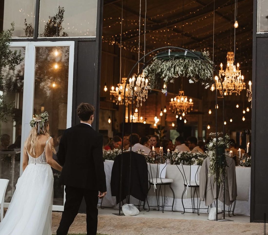 A bride and groom stepping into the candlelit barn at The Rose Barn