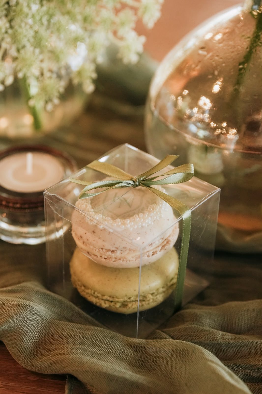 Macarons tied with an olive ribbon, a thoughtful detail at each place
